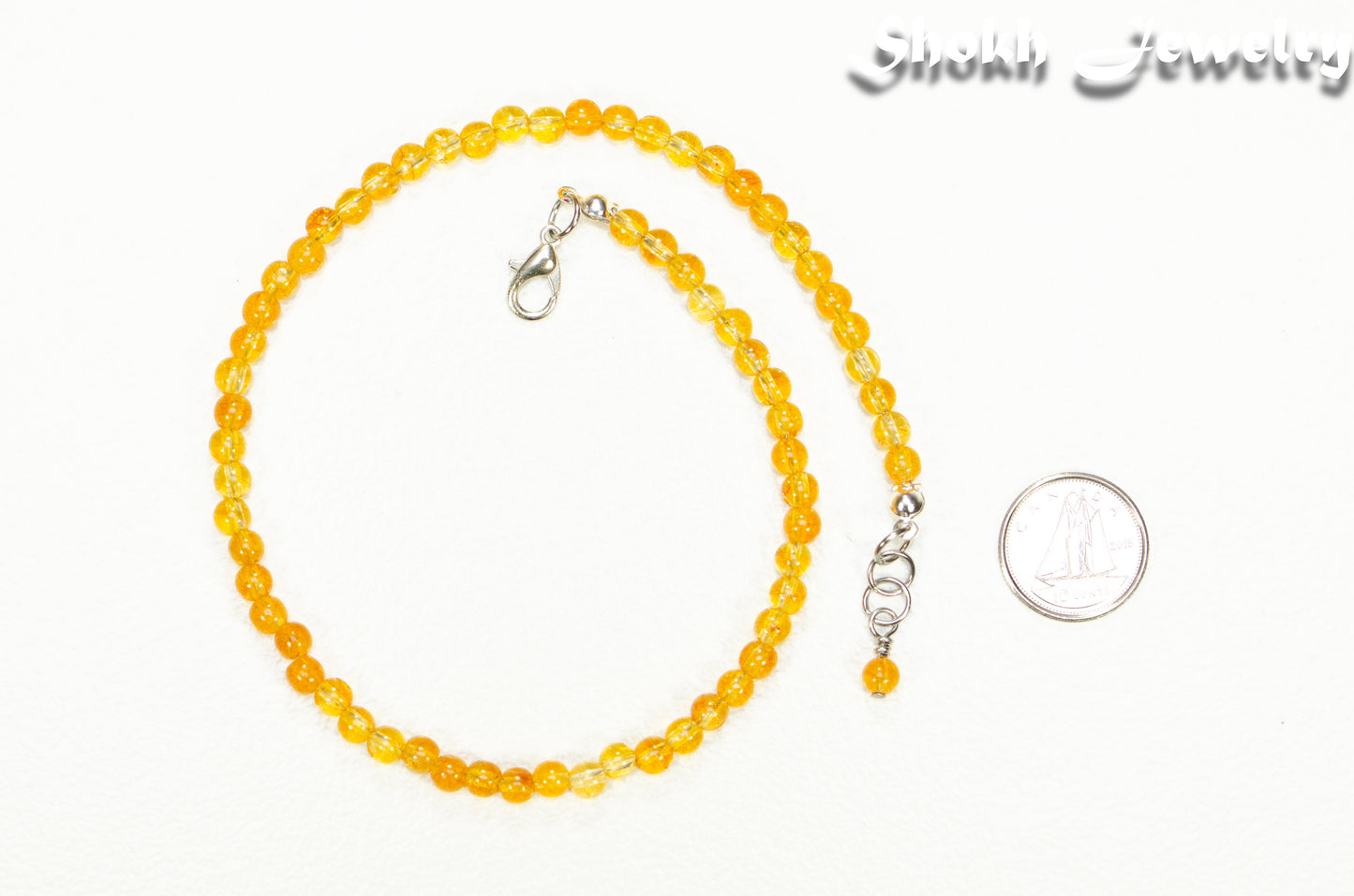 4mm Citrine Crystal Choker Necklace beside a dime.
