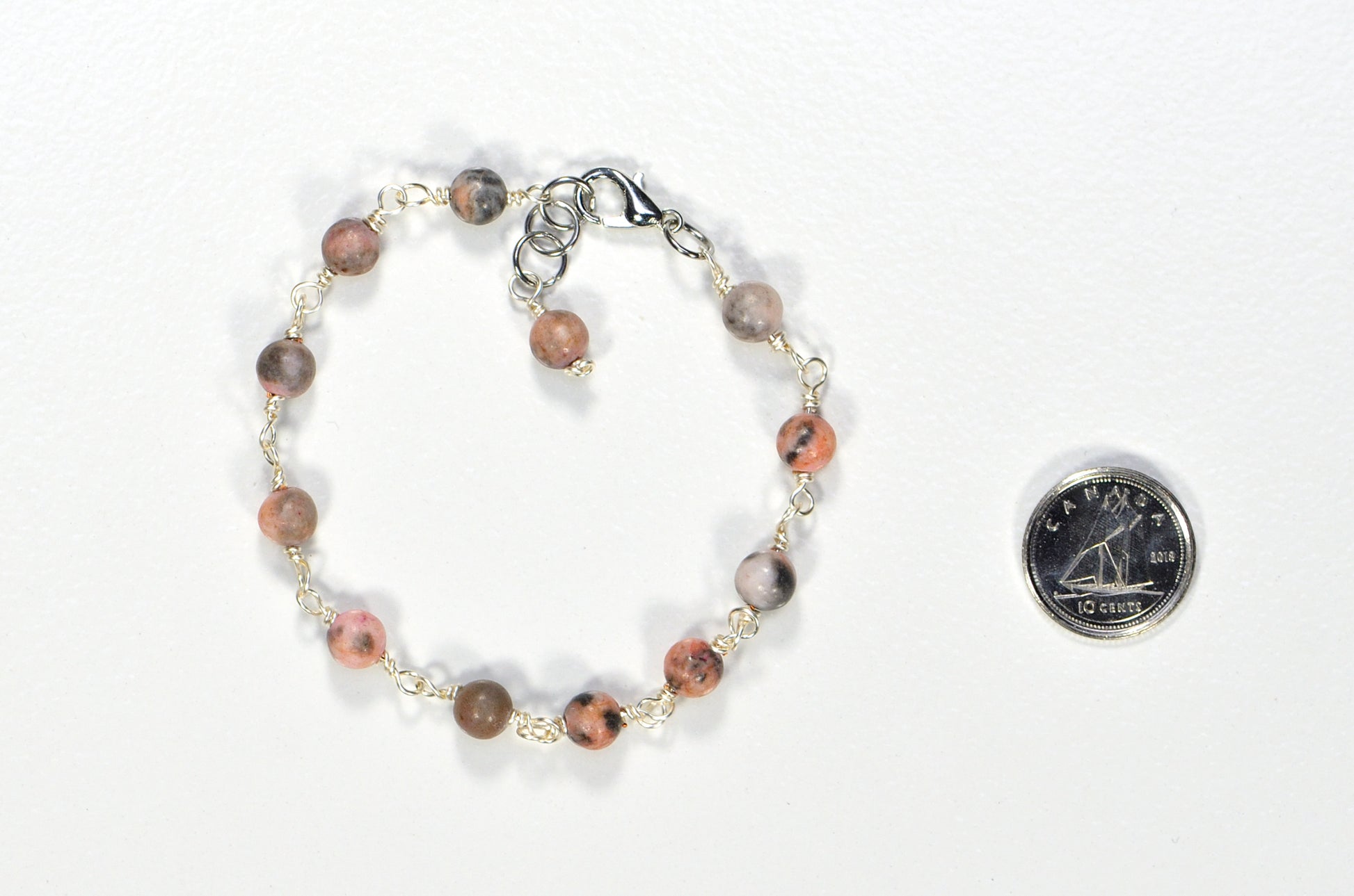 6mm Pink Zebra Jasper Link Bracelet eside a dime.