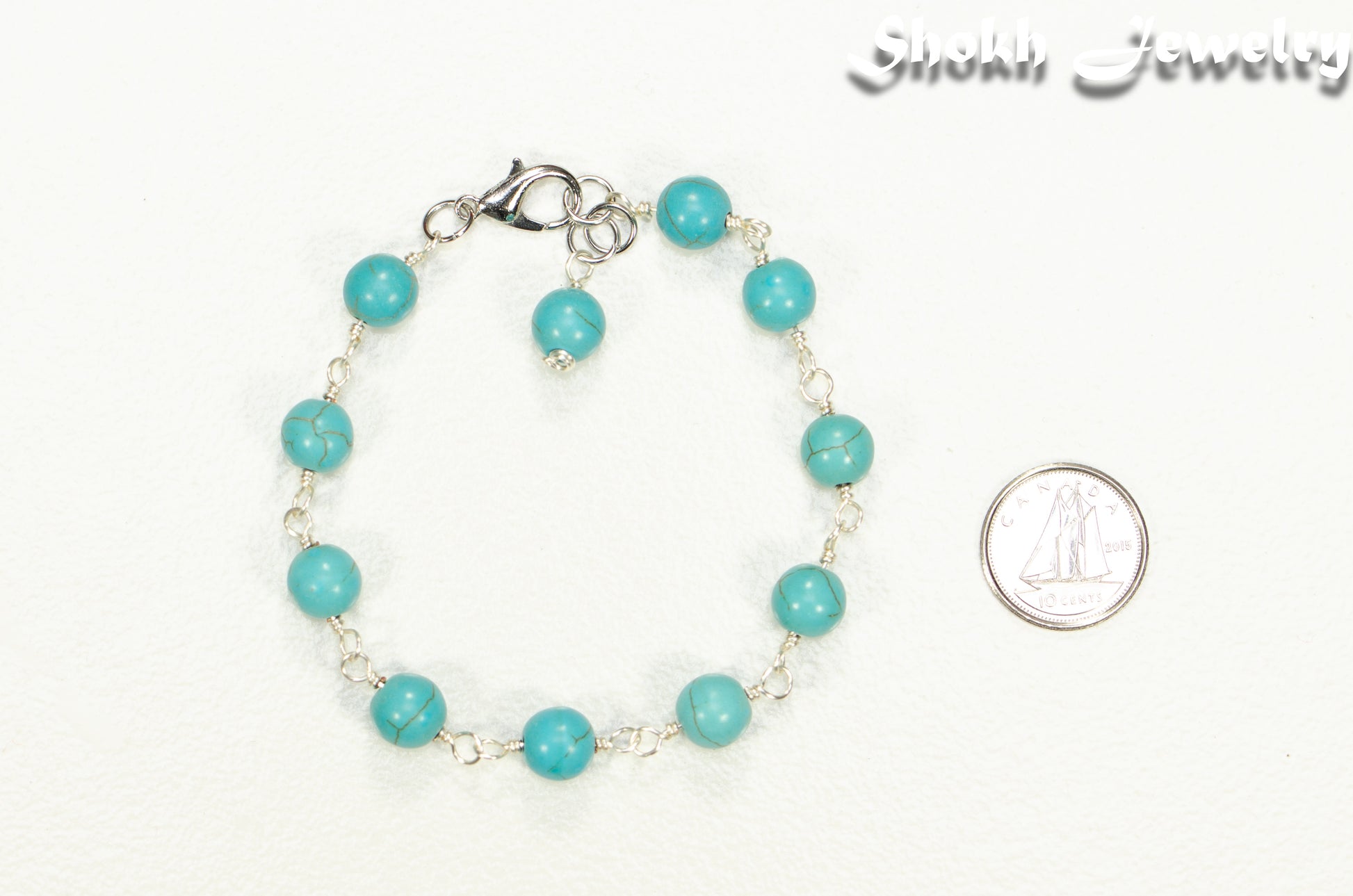 8mm Turquoise Howlite Link Anklet beside a dime.