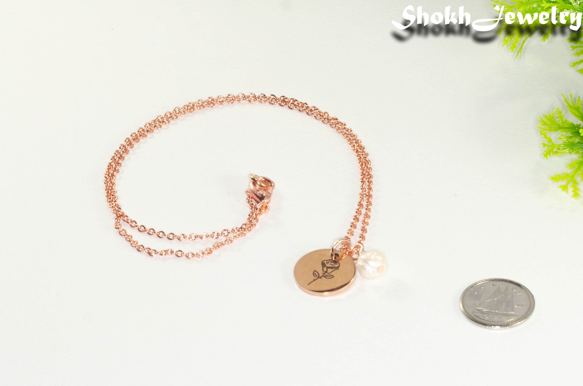 Rose Gold Plated June Birth Flower Necklace with Freshwater Pearl Pendant beside a dime.