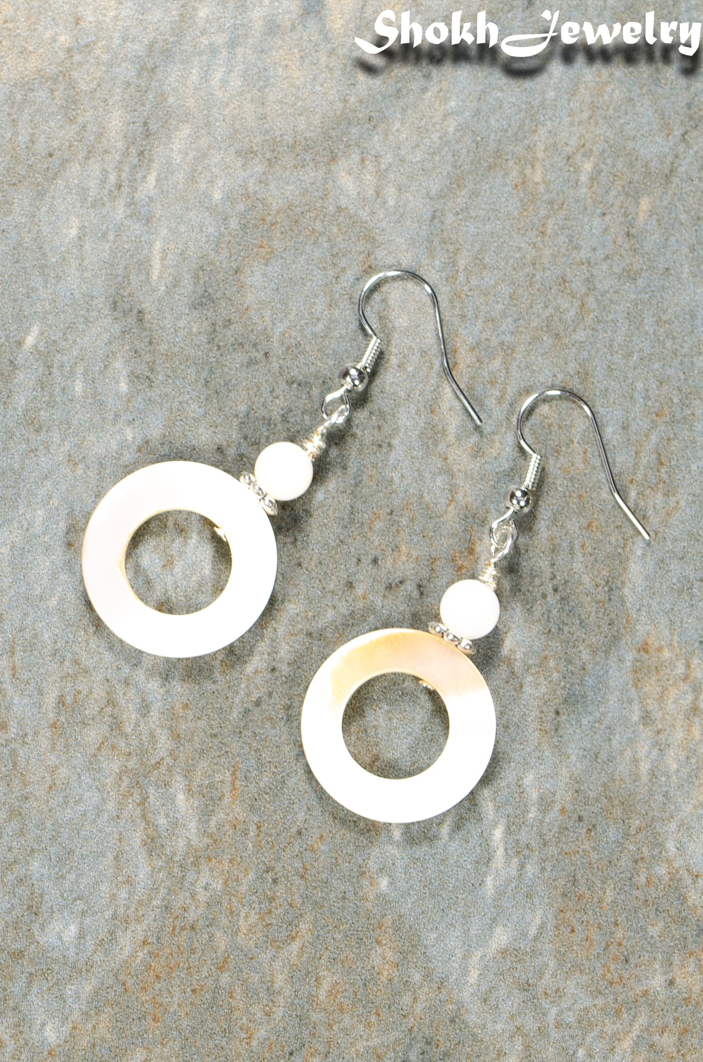 Top view of White Doughnut Seashell Earrings.