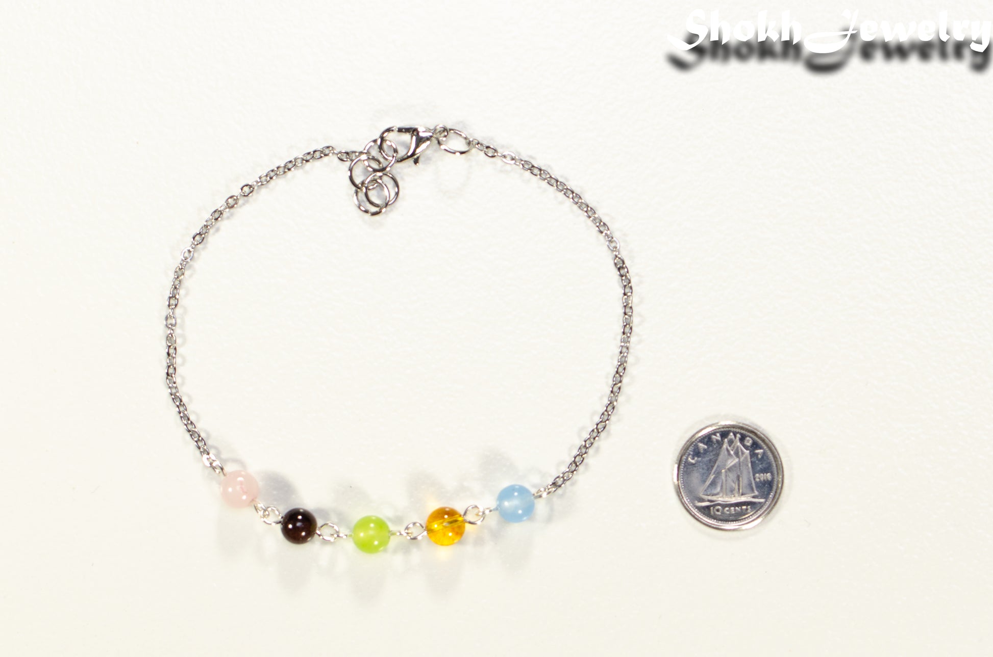 Custom Family Birthstone Anklet beside a dime