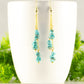 Long Gold Plated Chain and Turquoise Crystal Chip Earrings displayed on a coffee mug.