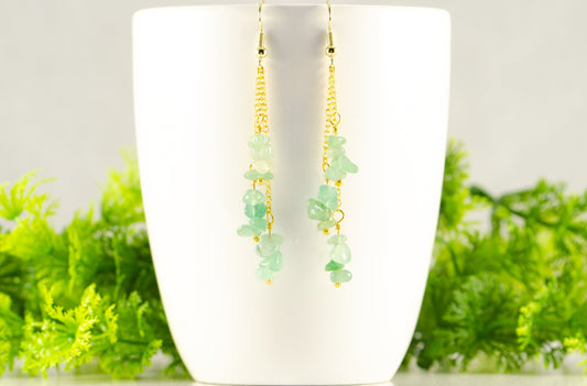 Long Gold Plated Chain and Green Aventurine Chip Earrings displayed on a coffee mug.