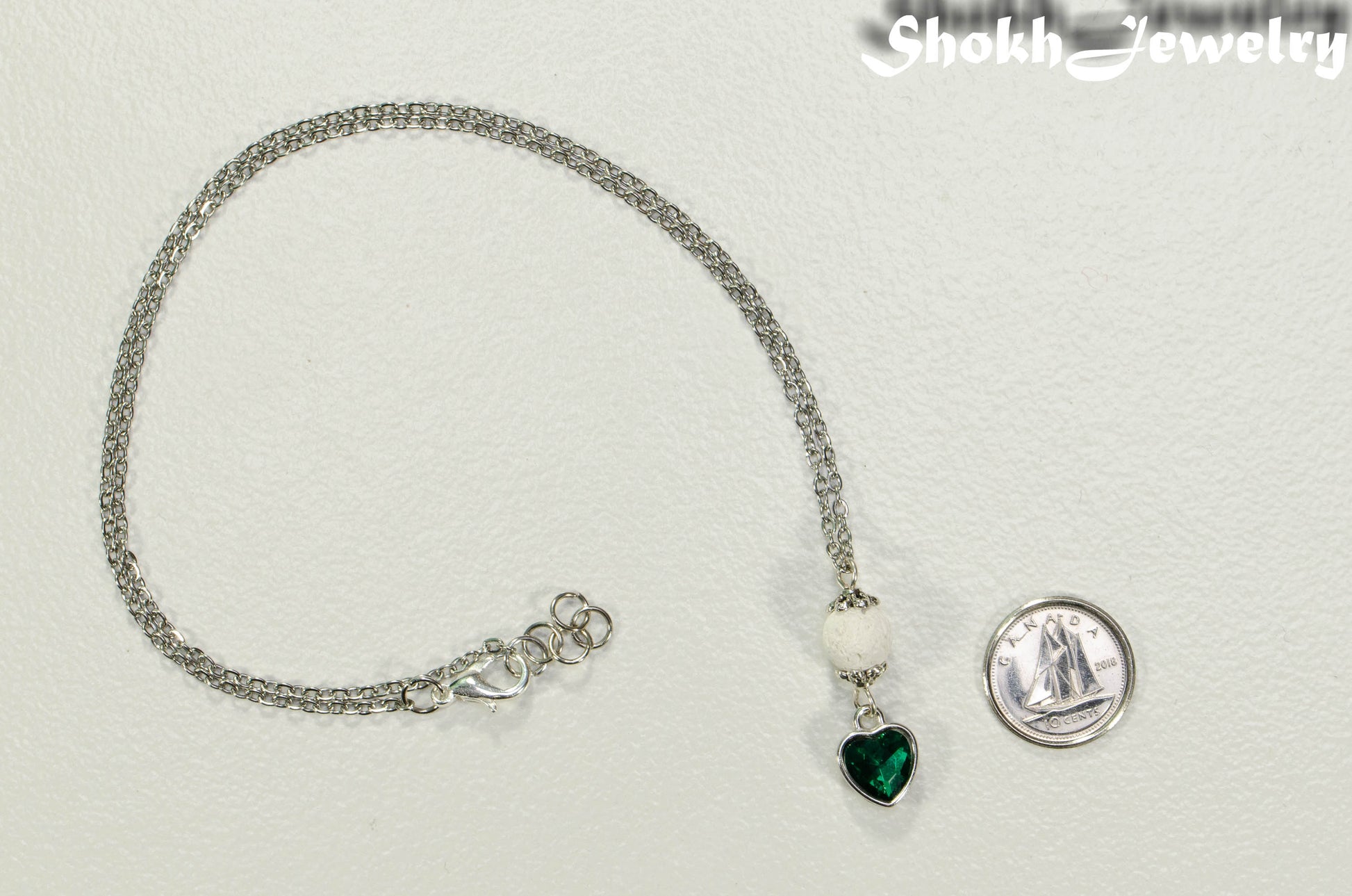 Lava Rock and Heart Shaped May Birthstone Choker Necklace beside a dime.