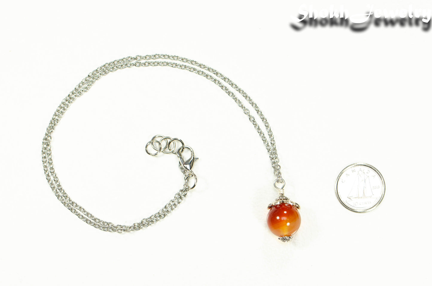 12mm Carnelian Pendant Necklace beside a dime.