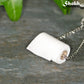 Close up of Miniature Toilet Paper Roll Necklace.
