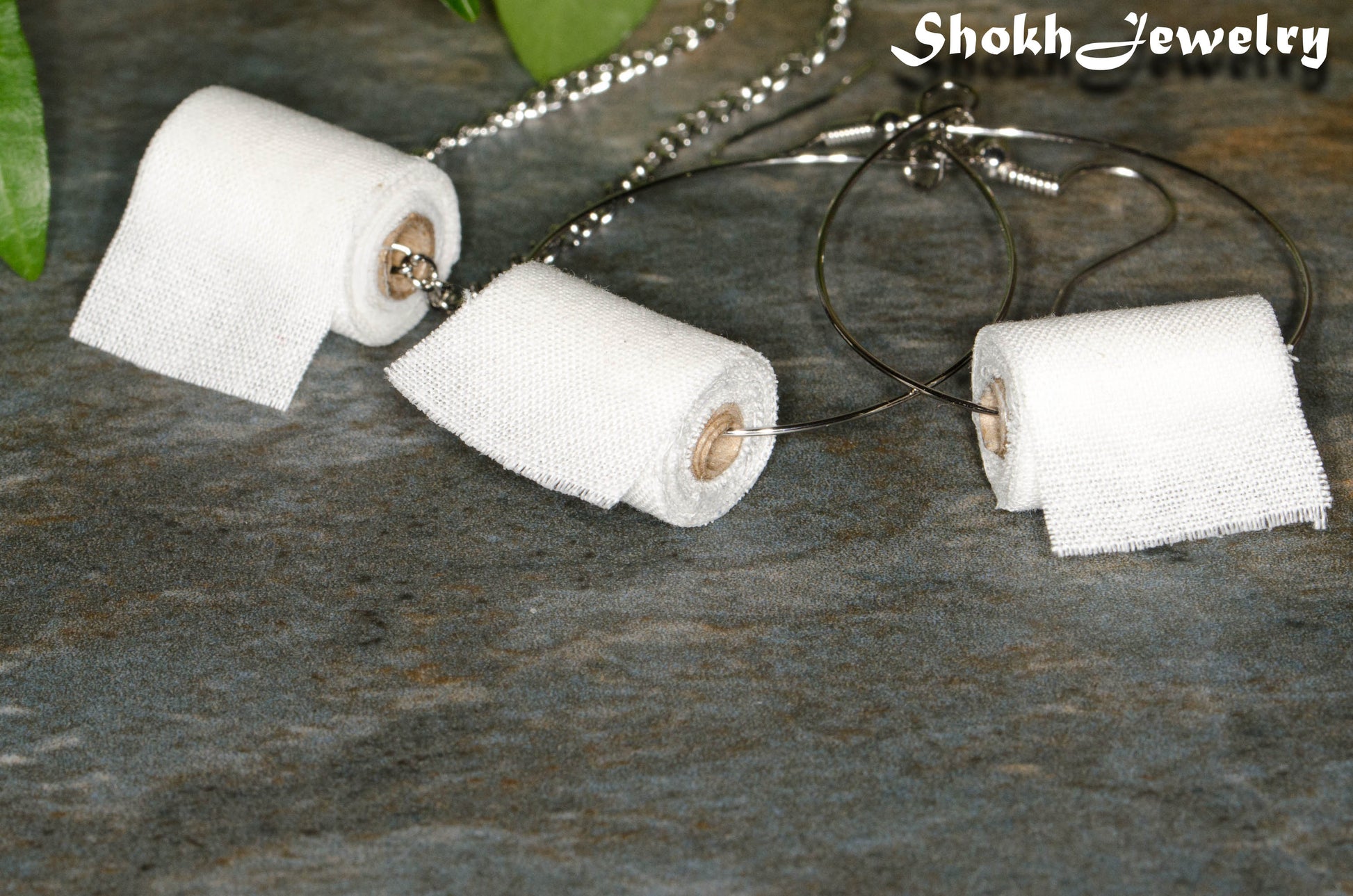 Close up of Miniature Toilet Paper Roll Necklace and Earrings Set.