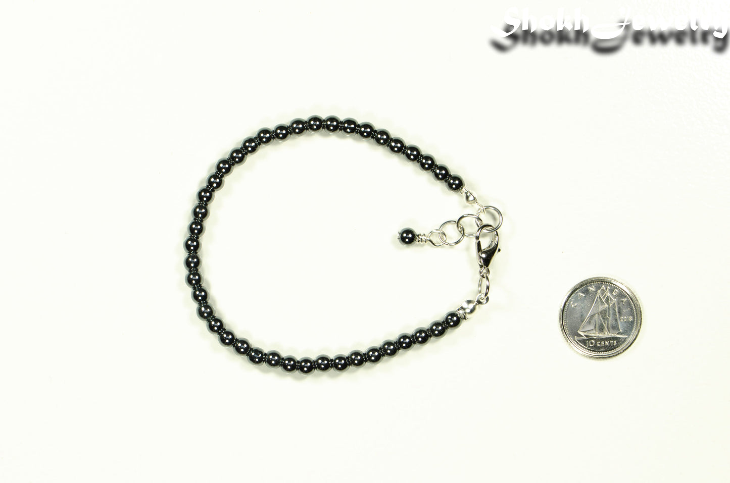 4mm Hematite Stone Anklet with Clasp beside a dime.