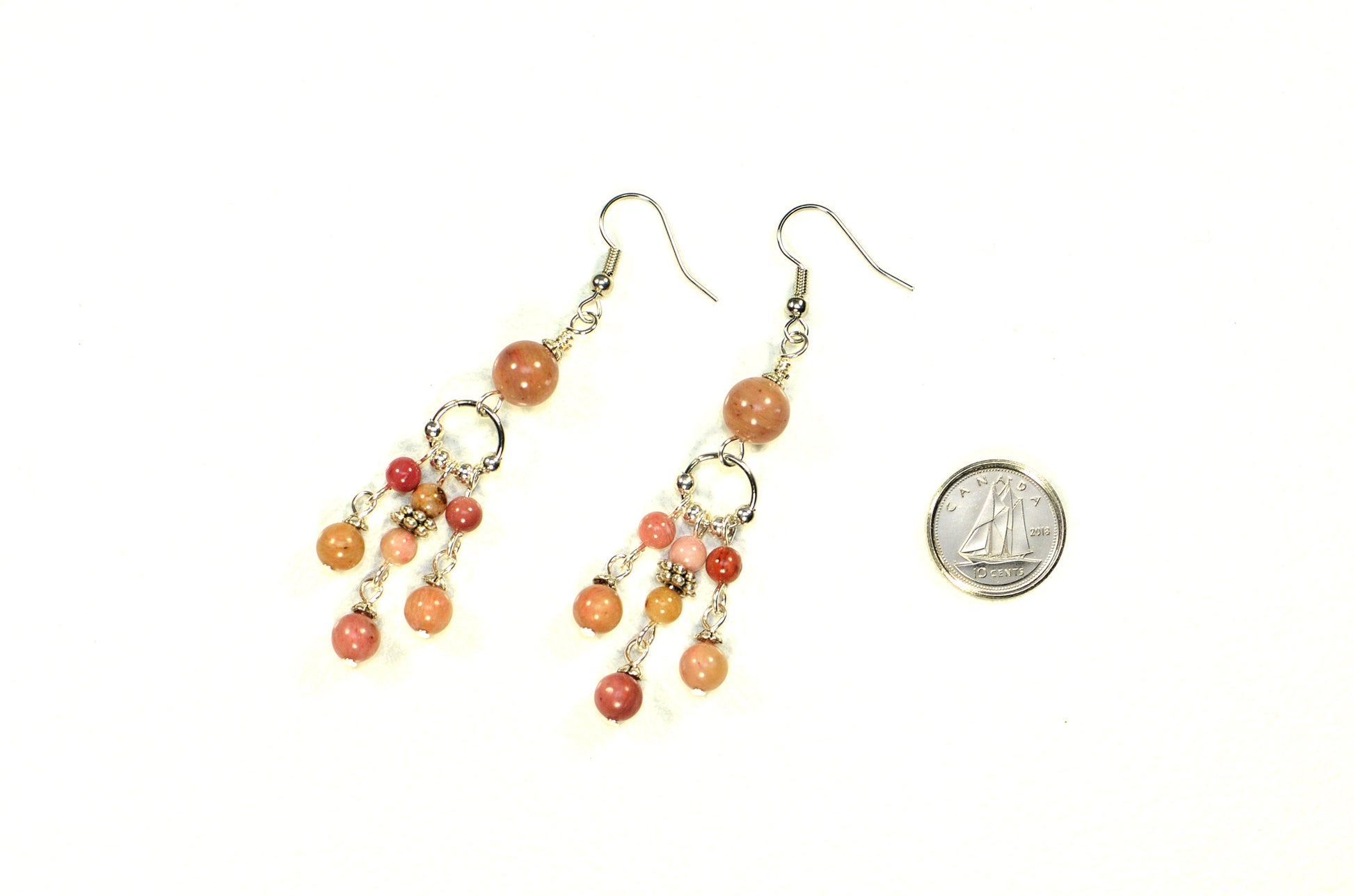 Statement Pink Rhodonite Chandelier Earrings beside a dime.
