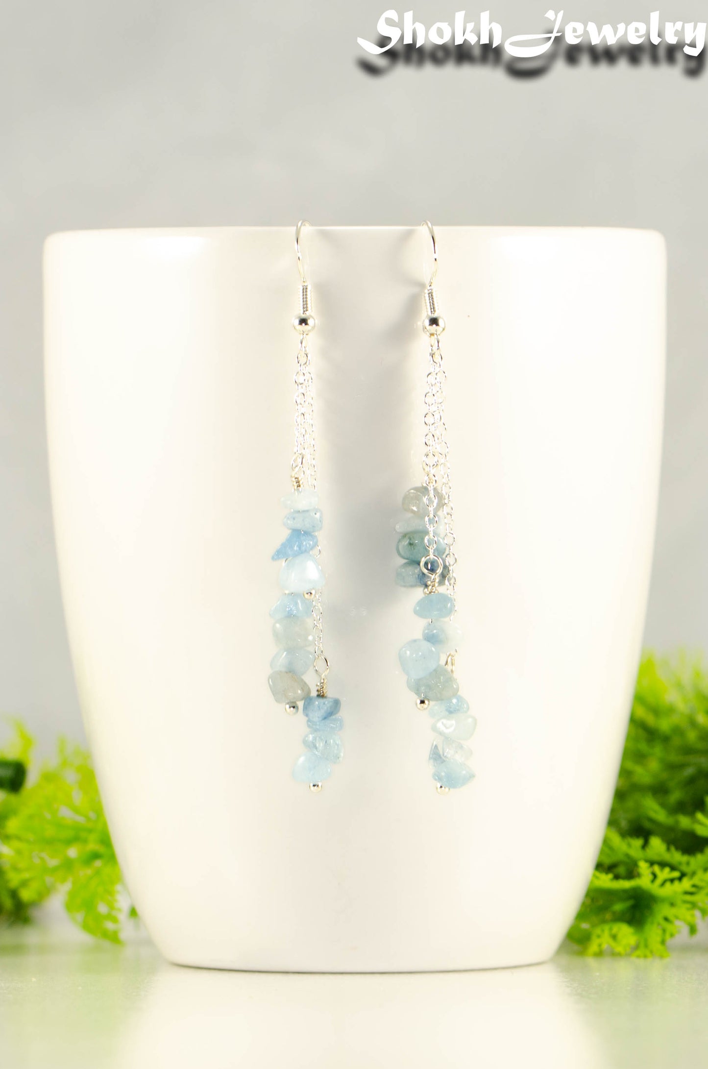 Long Silver Plated Chain and Aquamarine Crystal Chip Earrings on a mug