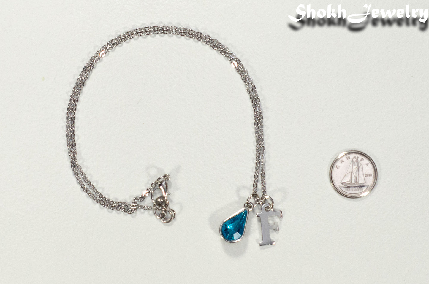 Personalized March Birthstone Choker Necklace beside a dime