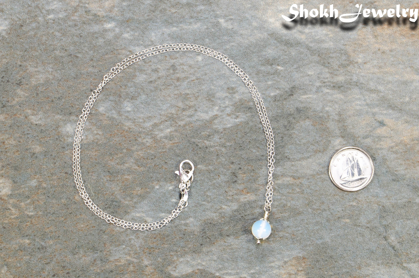 Dainty White Opal Choker Necklace beside a dime